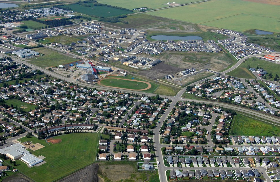 Aerial view of a suburban neighborhood with houses, roads, a school, and a baseball field.
